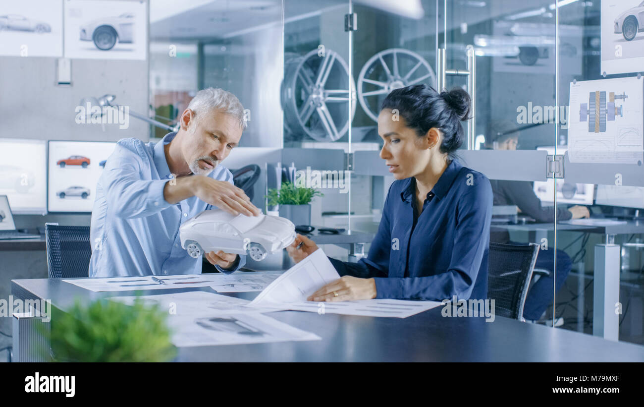 Designer automobile expérimenté et ingénieur femelle travaille avec un Concept Car Prototype, perfectionner et d'en produire des corrections de conception. Banque D'Images