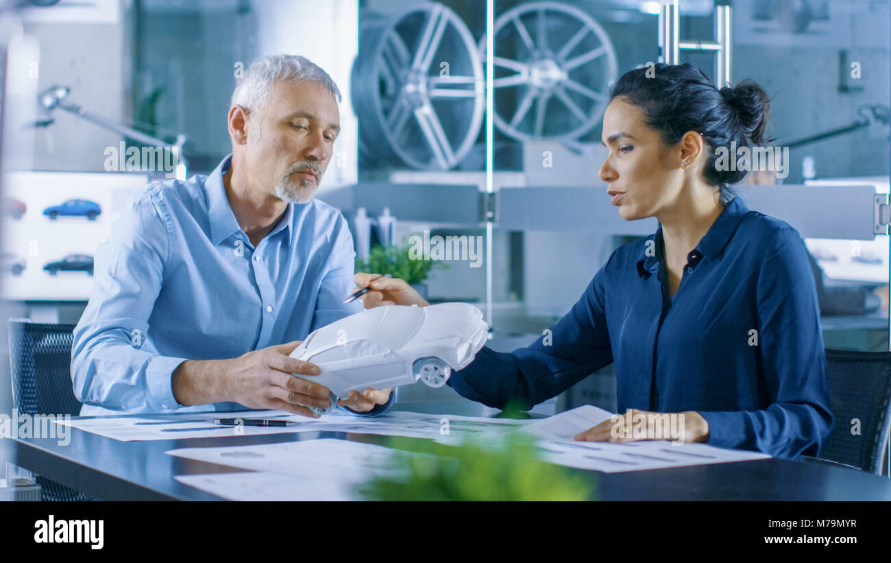 Designer automobile expérimenté et ingénieur femelle travaille avec un Concept Car Prototype, perfectionner et d'en produire des corrections de conception. Banque D'Images