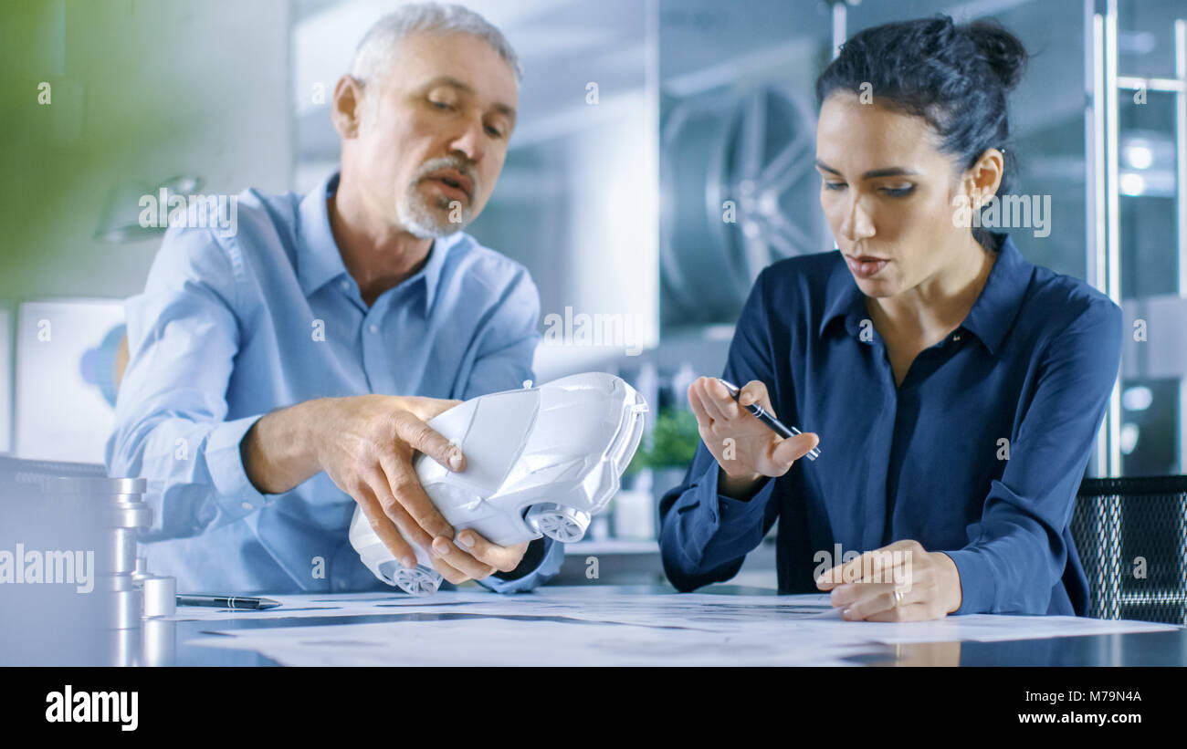 Designer automobile expérimenté et ingénieur femelle travaille avec un Concept Car Prototype, perfectionner et d'en produire des corrections de conception. Banque D'Images