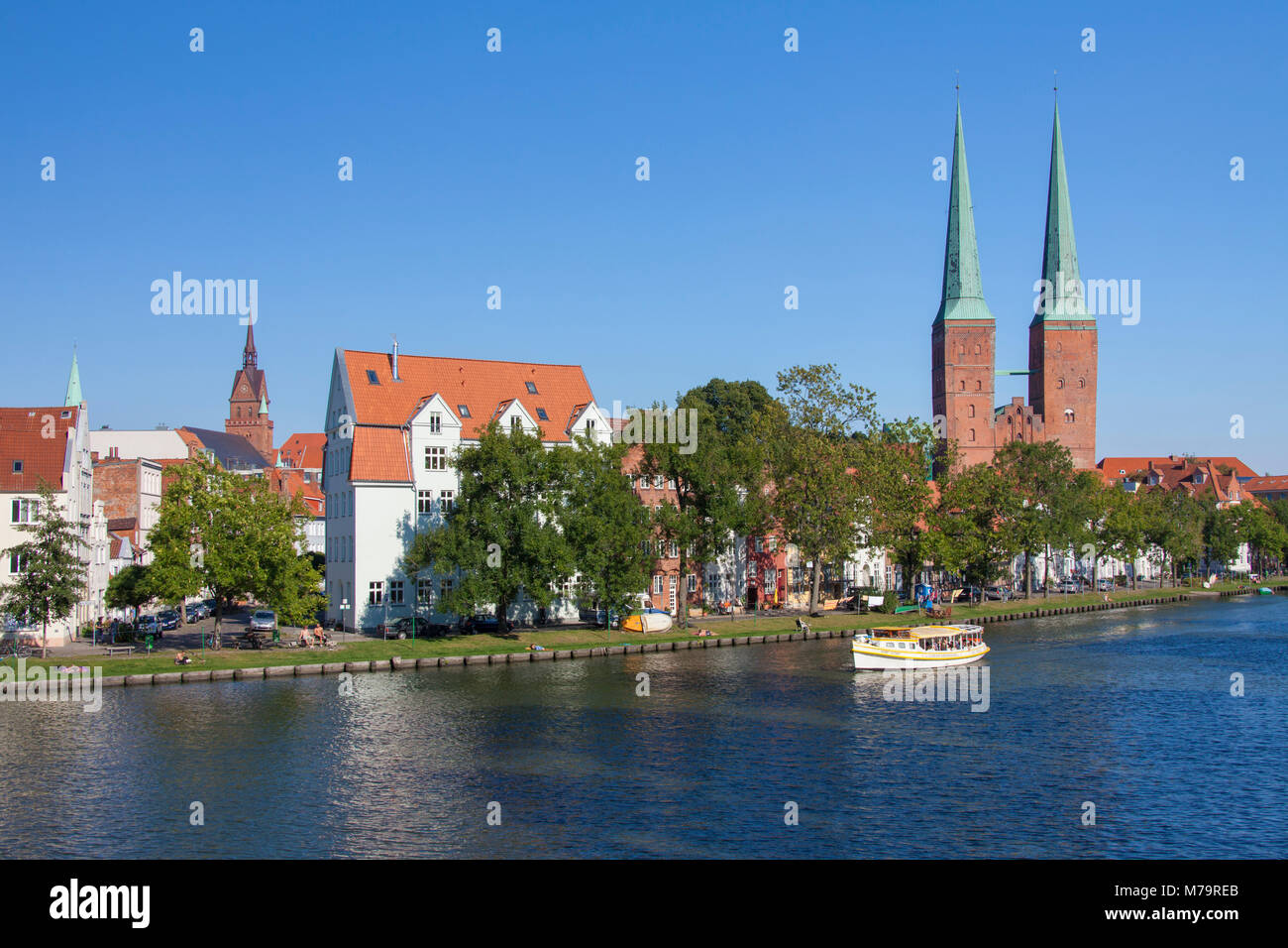 Bateau de tourisme sur la rivière Trave et la cathédrale de Lübeck / Dom zu Lübeck / Lübecker Dom dans la ville hanséatique de Lübeck, Schleswig-Holstein, Allemagne Banque D'Images