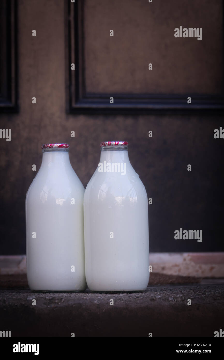 Des bouteilles de lait sur une porte avant l'étape d'une maison à Glasgow, Ecosse Banque D'Images