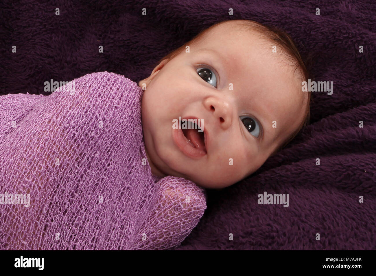 Bébé nouveau-né garçon heureux et confutable, emmailloté dans la douce couverture en pépinière, bébé emmailloté dans Banque D'Images