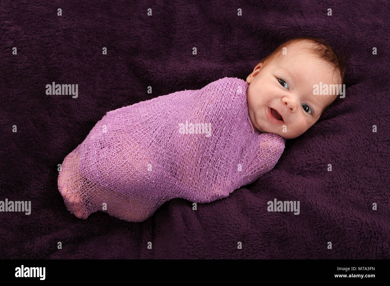 Bébé nouveau-né garçon heureux et confutable, emmailloté dans la douce couverture en pépinière, bébé emmailloté dans Banque D'Images