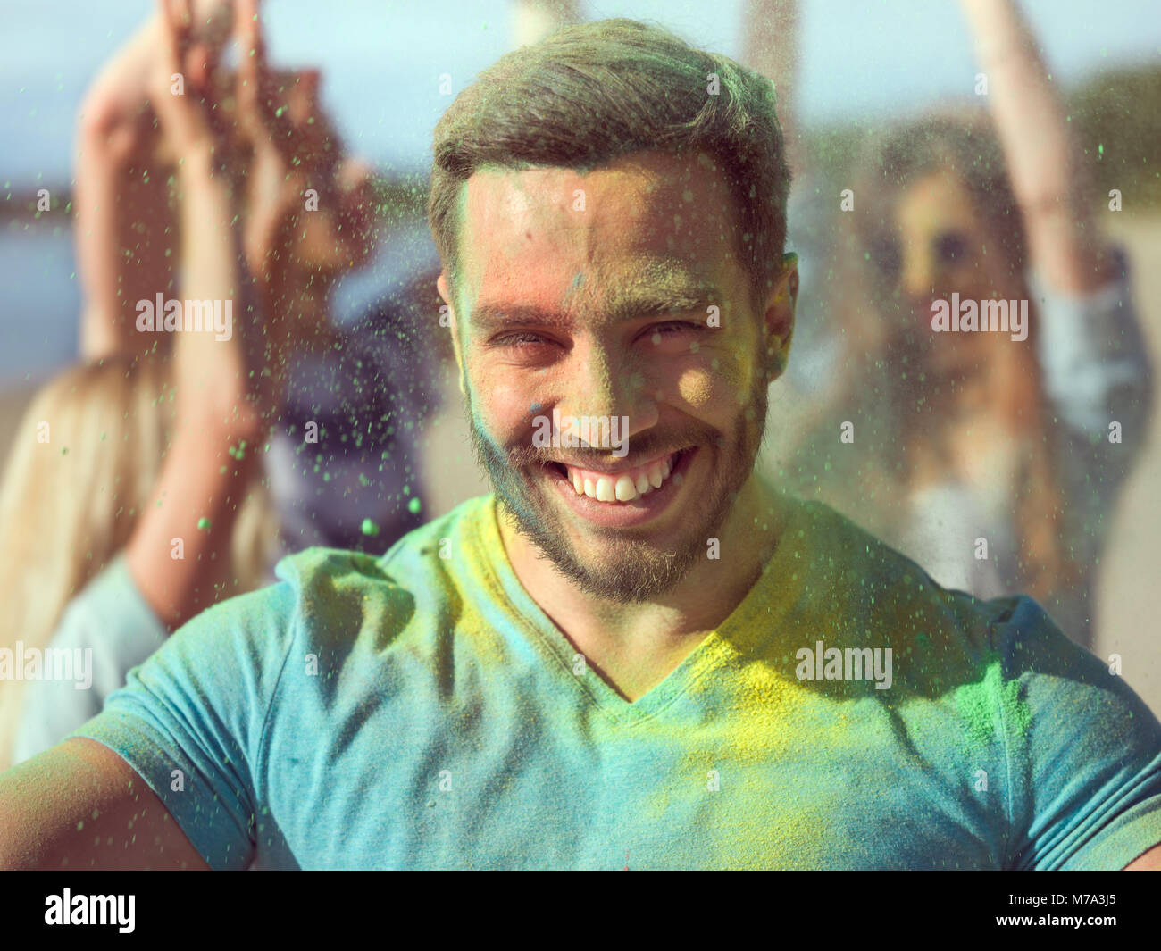 Portrait d'un selfies homme musclé de célébrer Holi Festival avec ses amis. Son visage et ses vêtements sont couverts de poudre colorée. Banque D'Images