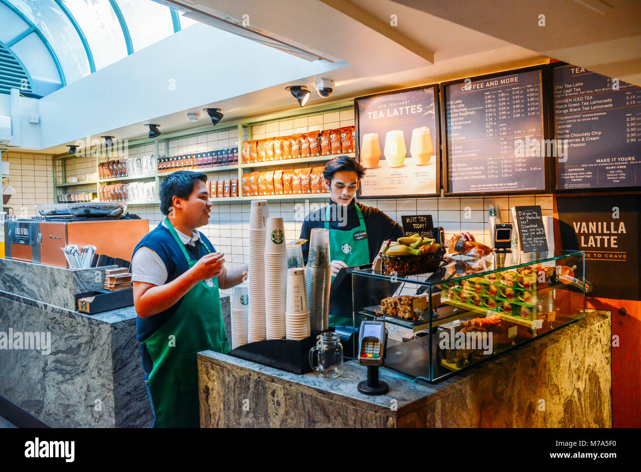 Londres, UK - 8 mars 2018 : Deux baristas de l'Asie du Sud-Est à un café Starbucks dans High Street Kensington, London, UK avec quelques lumière naturelle fro Banque D'Images