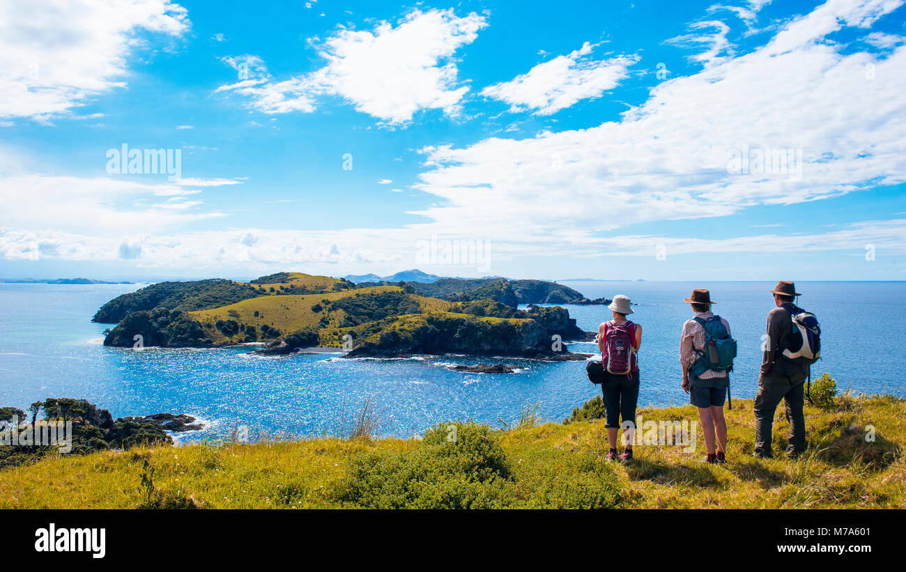 Randonneurs sur Urupukapuka Island dans la Bay of Islands, Île du Nord, Nouvelle-Zélande, en regardant vers l'île de Waewaetorea et distant Purerua Peninsula Banque D'Images