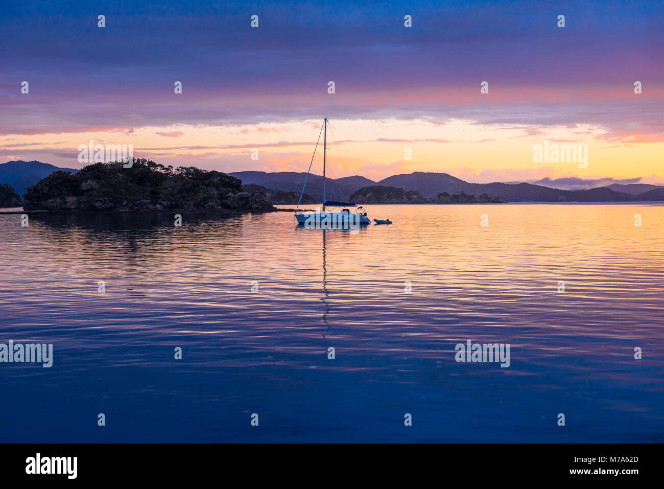 Coucher de soleil avec yacht ancré au large de l'Île Urupukapuka dans la Bay of Islands, Île du Nord, Nouvelle-Zélande Banque D'Images