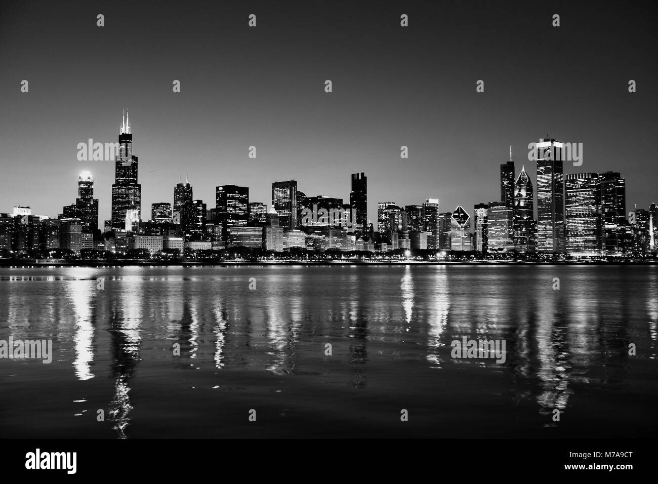 Chicago, Illinois, USA Skyline nuit sur le lac Michigan au crépuscule avec les villes Lumières se reflétant dans l'eau. Banque D'Images