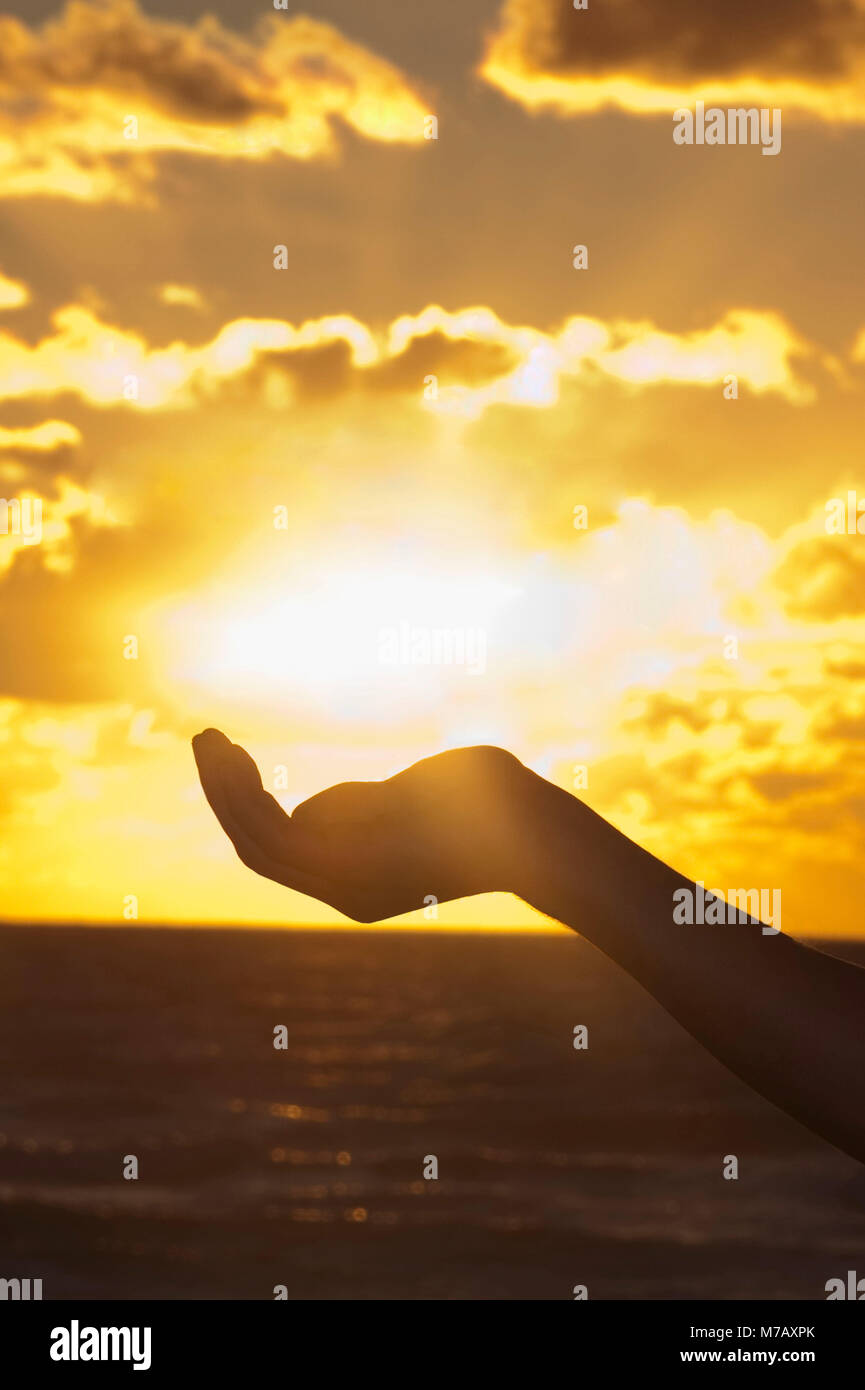 La main de l'homme prétendant détenir le soleil, South Beach, Miami Beach, Florida, USA Banque D'Images