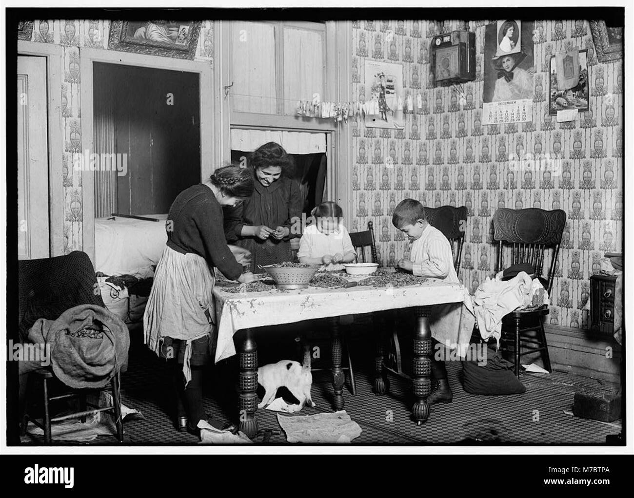 143, rue Hudson, rez-de-chaussée. Mme Salvia ; Joe, 10 ans ; Joséphine, 14 ans, Camille, 7 ans. Ramasser les noix dans un immeuble sale accueil. Le sac de noix concassé (au président) avait LOC CLB.05479 Banque D'Images