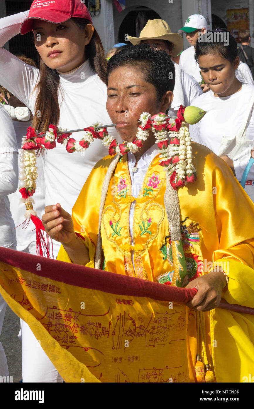 Femme avec une broche à travers sa joue dans un défilé pendant les neuf dieux empereur festival (festival végétarien) à Phuket, Thaïlande Banque D'Images