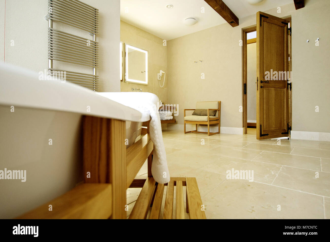 Belle baignoire blanc pour une porte ouverte. Baignoire se trouve dans un cadre en bois Banque D'Images