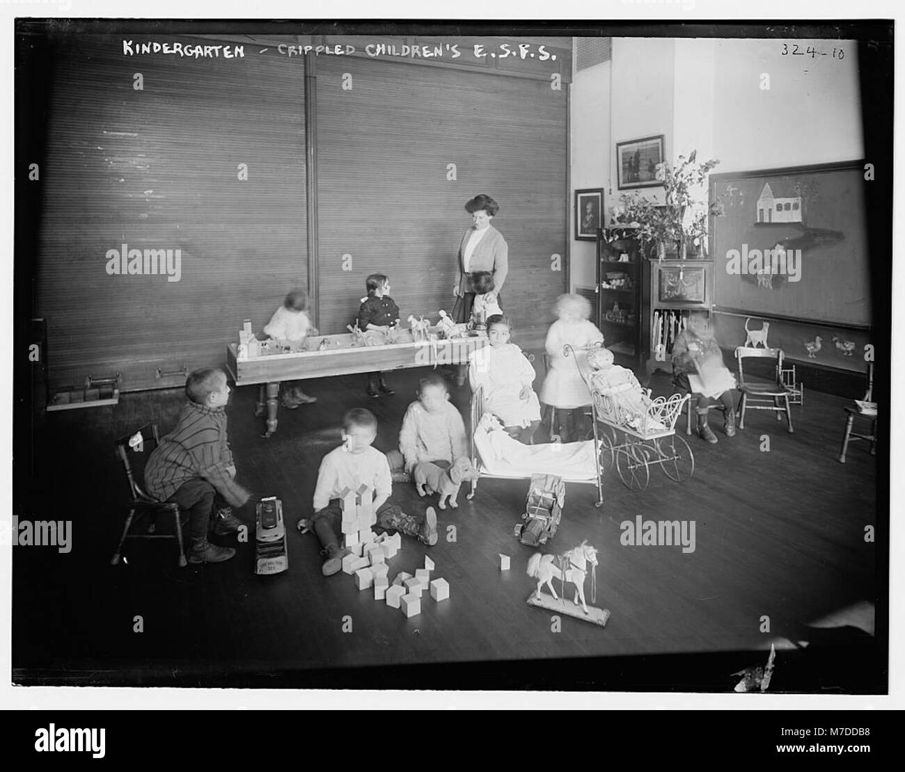 Les enfants handicapés de la Kindergarten Crippled Children's East Side Free School s'engagent dans des activités d'apprentissage, mettant en valeur le soutien éducatif et les soins aux enfants ayant des besoins spéciaux. Banque D'Images
