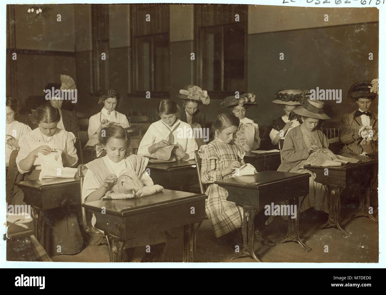 Photographie d'élèves apprenant à broder dans un programme d'école du soir gratuit en 1909. L'image met en lumière les initiatives éducatives et le développement des compétences de la classe ouvrière au début du XXe siècle. Banque D'Images