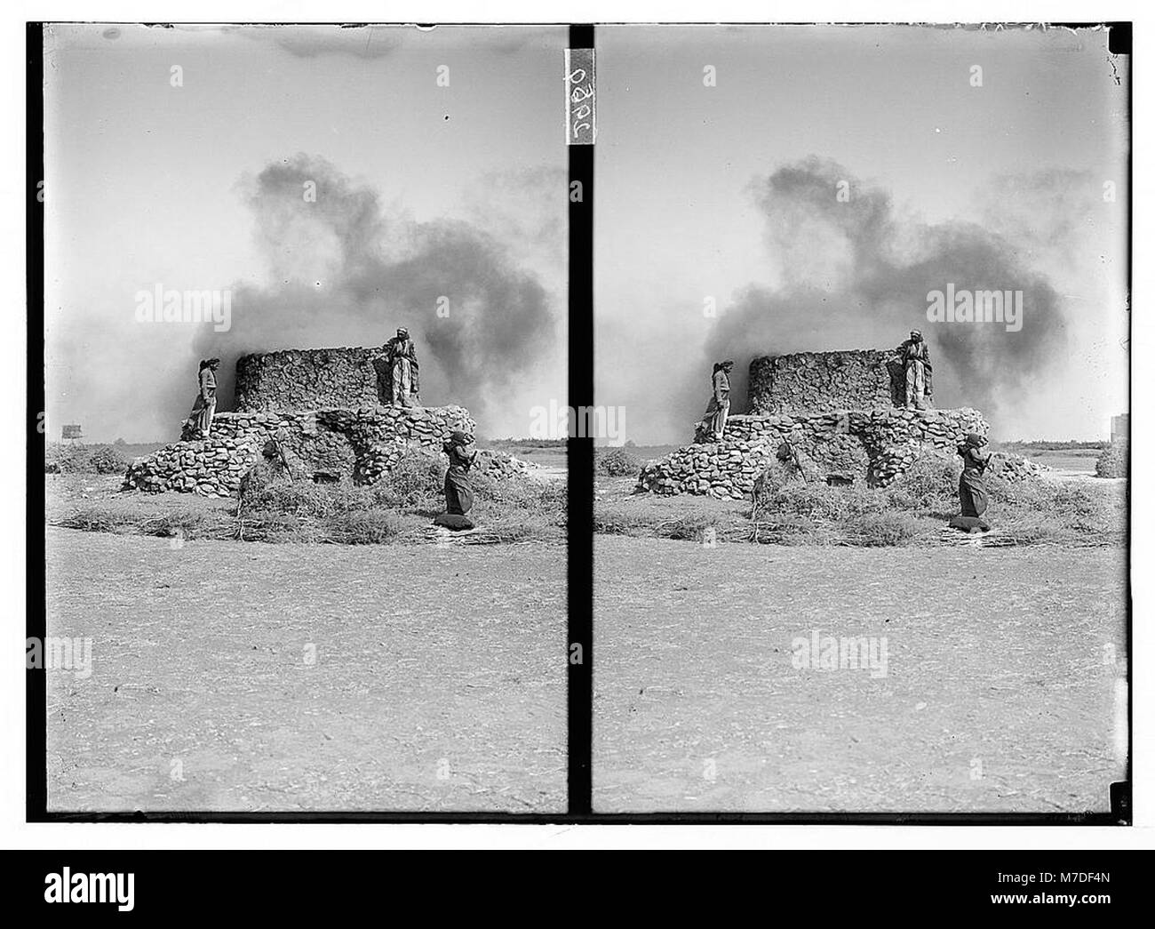 Cette image représente une opération de four à chaux près de Homs, montrant la combustion d'épines dans le cadre du processus de production de chaux. Le four à chaux est une méthode traditionnelle utilisée pour produire de la chaux en chauffant le calcaire avec du bois ou d'autres matériaux. Banque D'Images