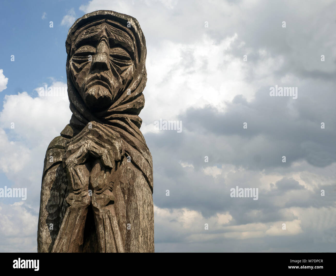 Sculpture en bois d'une femme âgée dans une écharpe contre un ciel bleu  avec des nuages dans le château Palanok, Izki, ouest de l'Ukraine Photo  Stock - Alamy