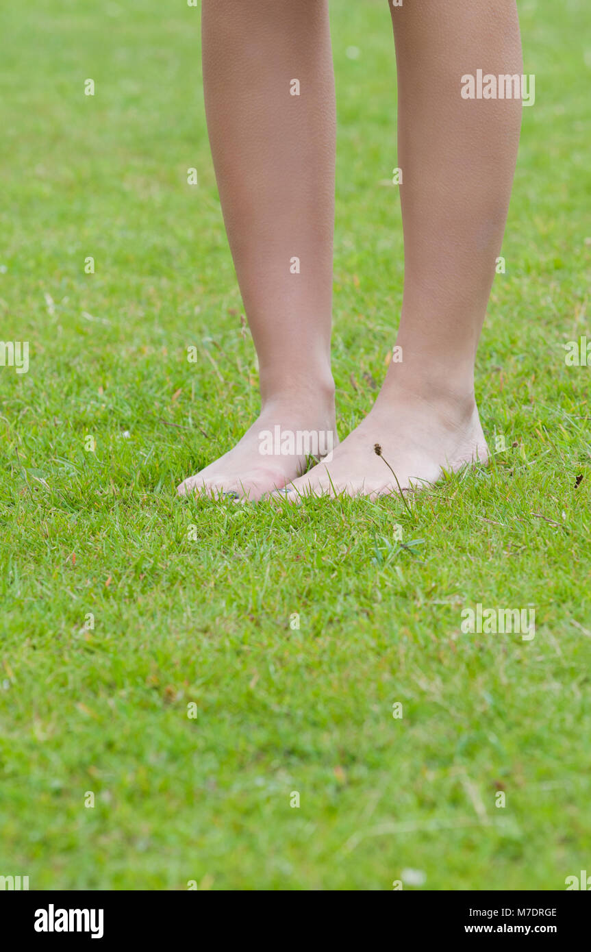 Gros plan d'une jeune femme debout, pieds nus sur l'herbe Banque D'Images