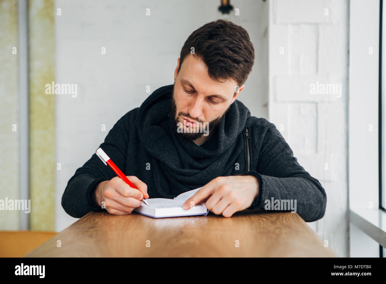 Jeune homme portrait sur un bloc-notes sur bois 24 dans le café café shop Banque D'Images