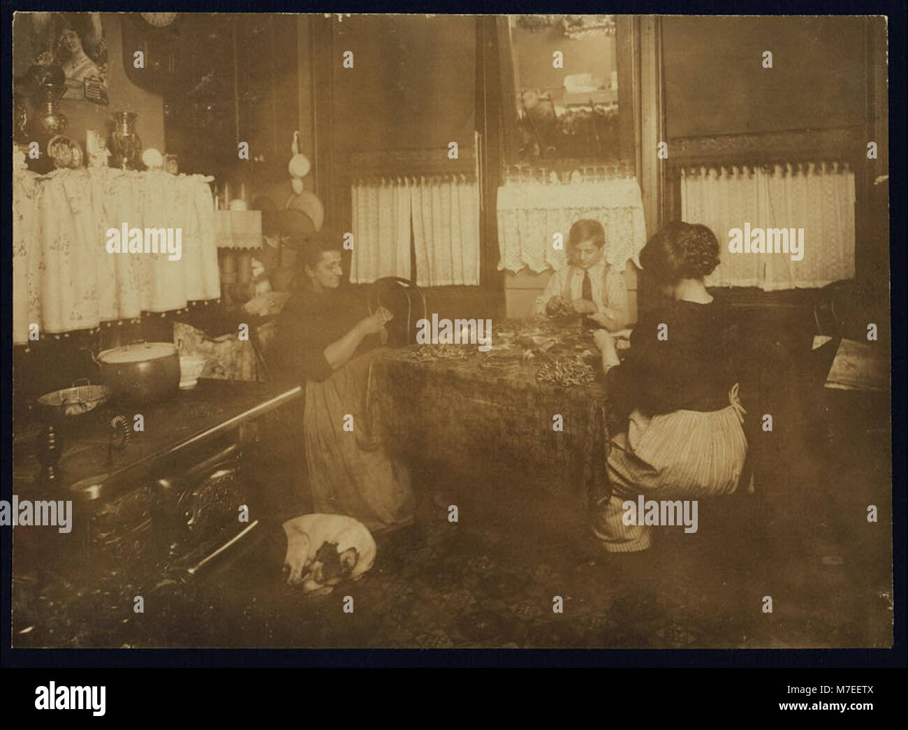 Une photo prise après 21 H mettant en scène MRS Barattini, concierge au 212 Sullivan préparé, N.Y., avec son fils de 14 ans, Louis, et sa fille. La fille travaille dans une usine de fleurs pendant la journée et aide sa mère à fabriquer des produits la nuit. Banque D'Images