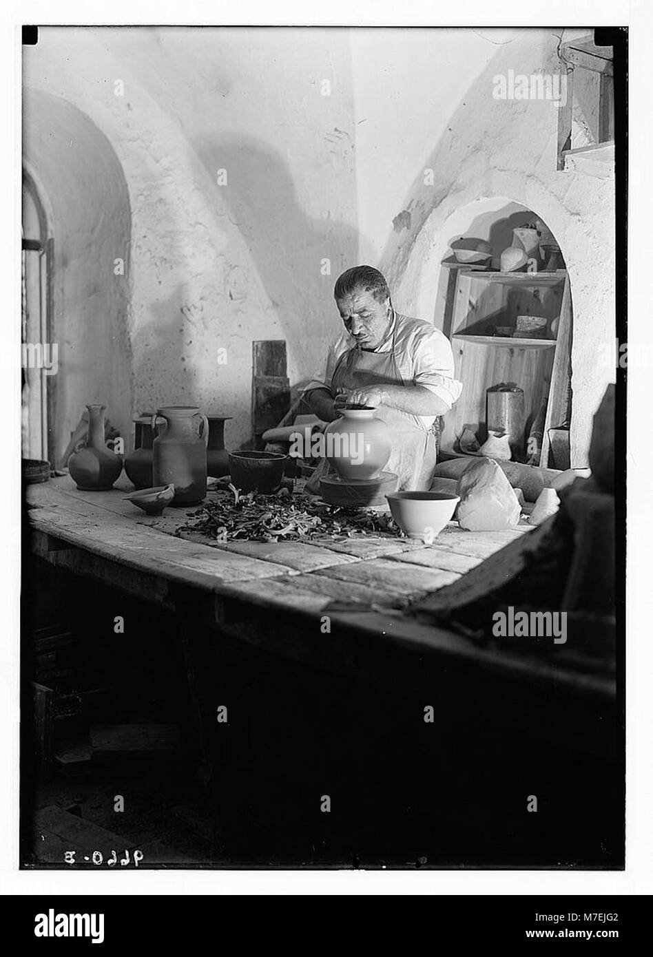 Un potier travaillant à sa roue de tour, fabriquant des poteries à la main. L'image capture l'habileté et la technique impliquées dans les processus traditionnels de fabrication de poterie. Banque D'Images