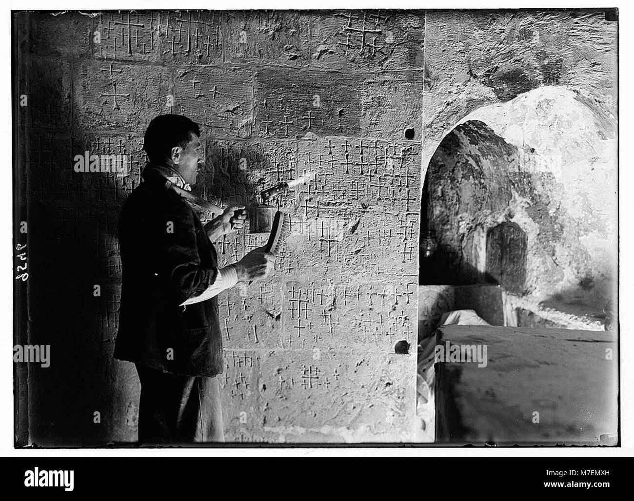 Les travaux de réparation dans l'église du Saint-Sépulcre montrent le nettoyage du vieux plâtre de son parement de pierre, révélant de nombreuses croix sculptées dans la pierre, reflétant la longue histoire de l'église. Banque D'Images