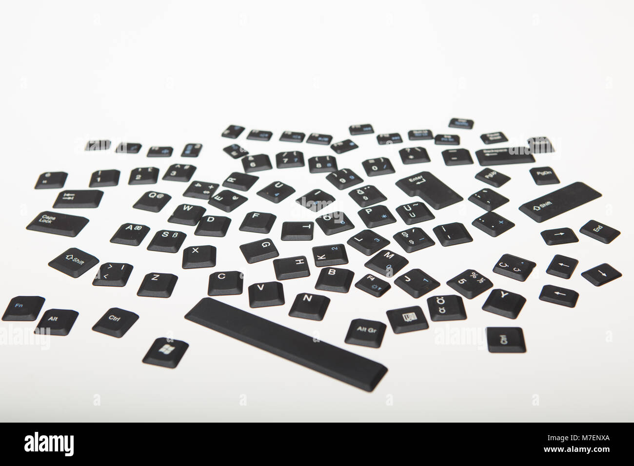 Les caches des alphanumérique touches sur un clavier d'ordinateur dans un enchevêtrement aléatoire sur un fond blanc ou fond argenté vu de l'angle faible Banque D'Images