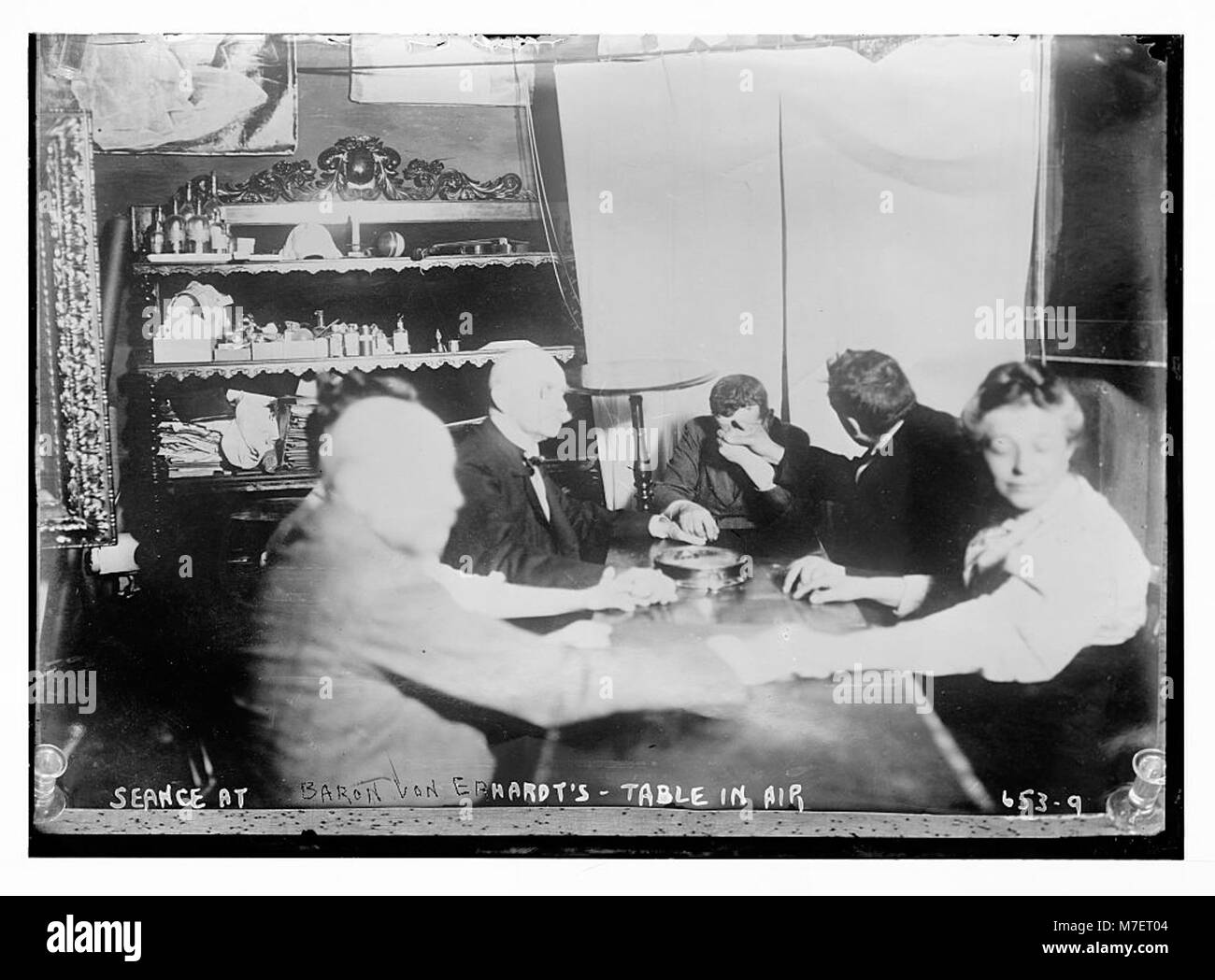 Une photographie capturant une séance à la résidence du baron von Erhardt, où une table est vue en lévitation lors d’un rassemblement spiritualiste. Banque D'Images