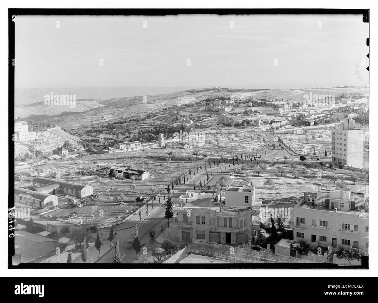 Un paysage enneigé au sud de Jérusalem, avec des zones résidentielles visibles au loin, mettant en valeur les caractéristiques naturelles et architecturales de la région. Banque D'Images