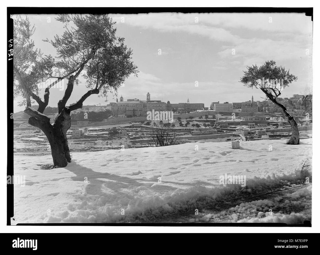 Une vue enneigée de Bethléem, montrant l'église de la Nativité, un monument chrétien important, vu de la route J'lem-Bethléem. L'image capture l'église emblématique dans une scène hivernale, soulignant son importance historique et religieuse. Banque D'Images