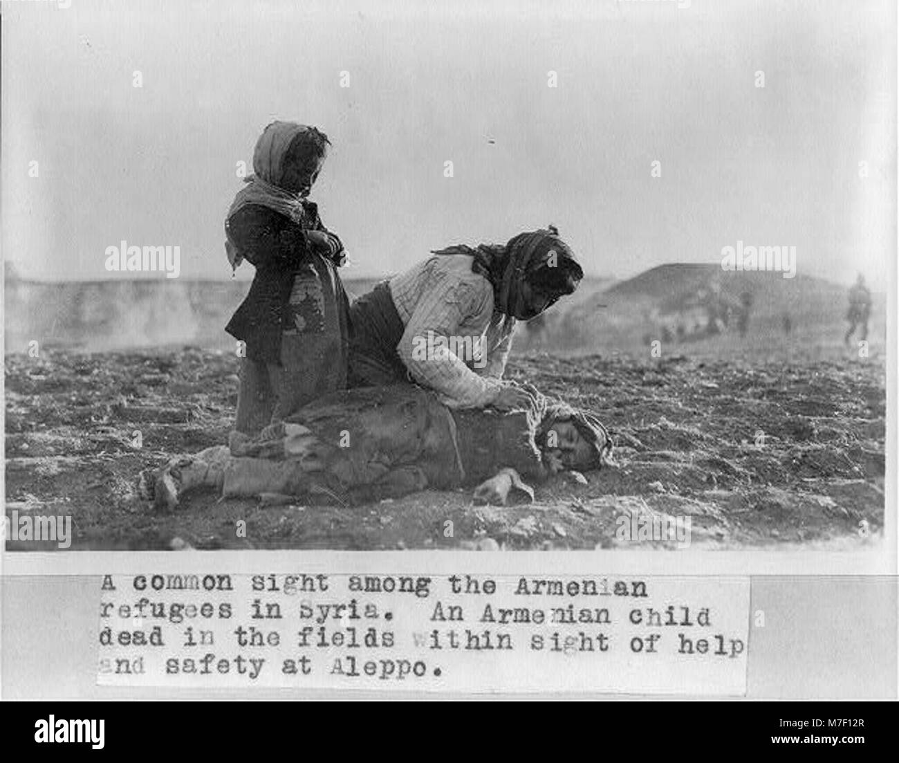Une scène poignante à Alep, en Syrie, où une femme arménienne est représentée agenouillée à côté de son enfant décédé dans un champ. Cette image souligne le coût humain des conflits dans la région en temps de guerre. Banque D'Images