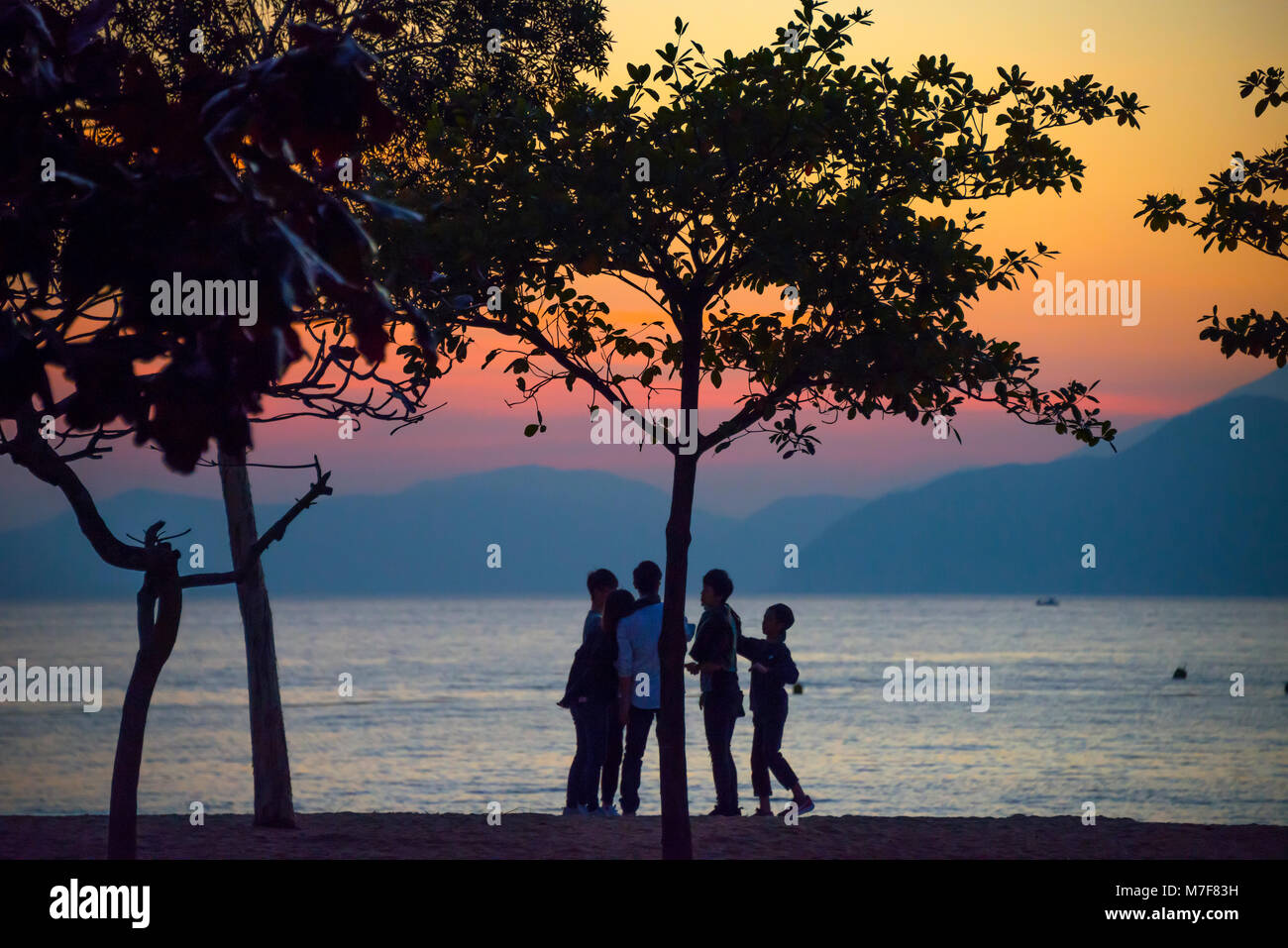 Enfants jouant au coucher du soleil, Repulse Bay, Hong Kong Banque D'Images
