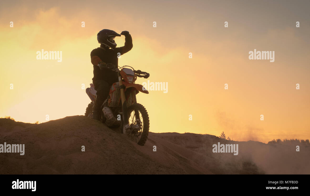 Motocross professionnel spectaculaire de motards se dresse sur la Dune hors route sur sa moto enduro. Regarde loin sur l'ensemble de la piste. Banque D'Images