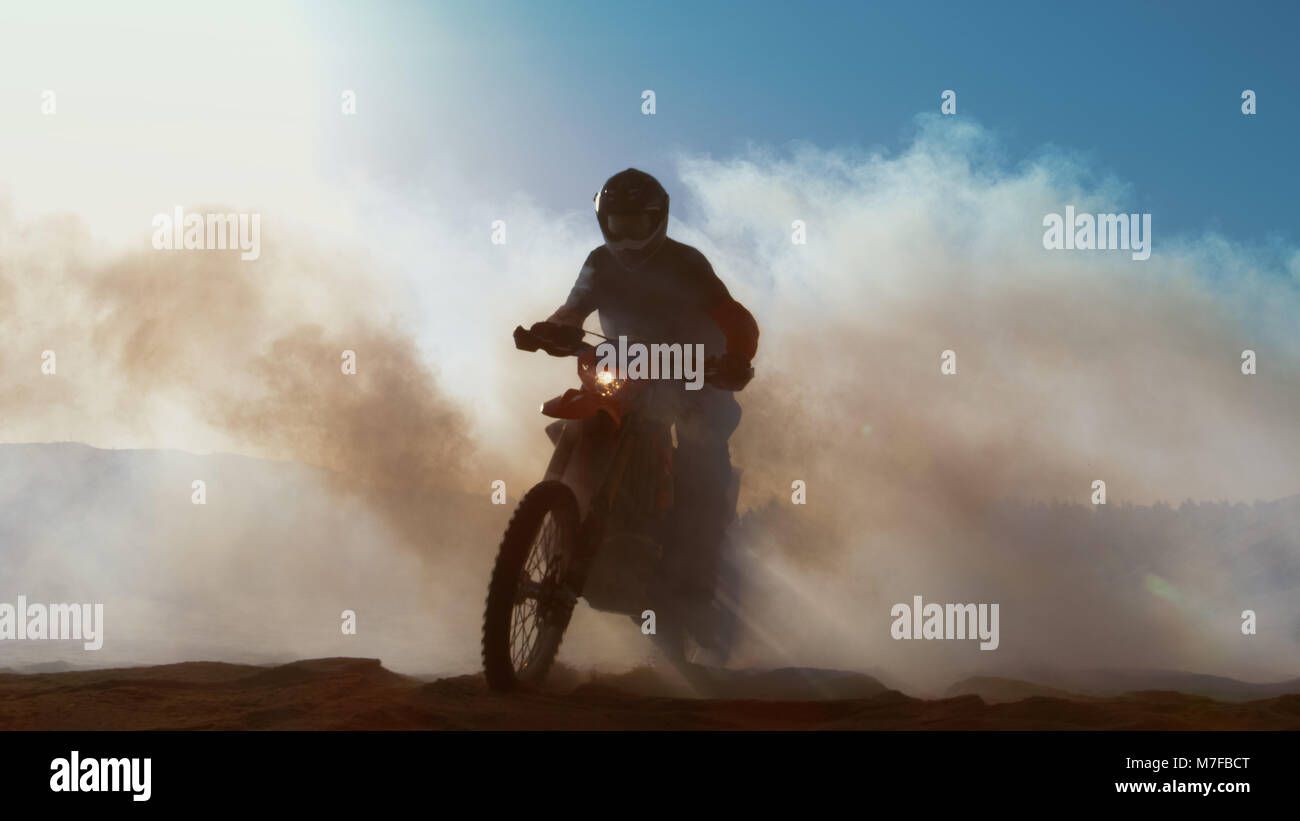 Pilote Moto Motocross professionnels durs à travers la fumée et brume sur la route de terre. Banque D'Images