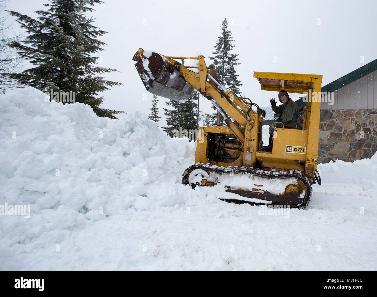 Pelle hydraulique déneigement de la route en hiver Photo Stock - Alamy
