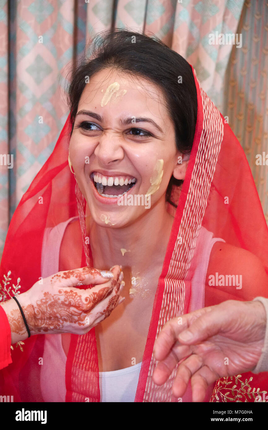 Cérémonie de mariage indien bénédiction avant d'être mariée avec la pâte de curcuma enduite sur le visage par des parents Banque D'Images