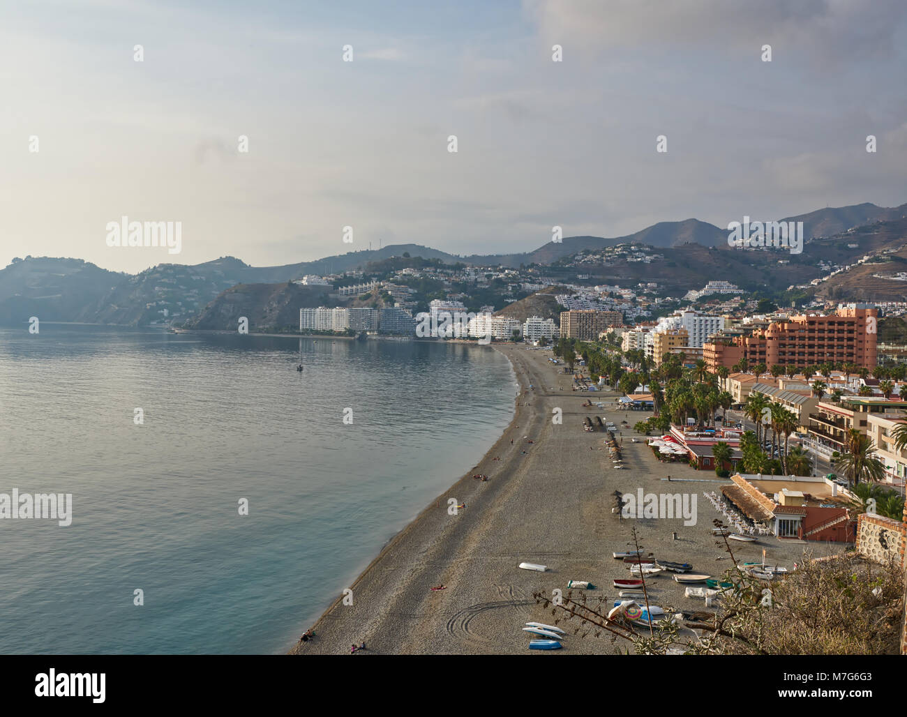 Almunica plage et bord de mer en Andalousie, espagne. Certaines personnes s'asseoir sur la plage pour regarder le coucher du soleil sur la mer méditerranée. Banque D'Images