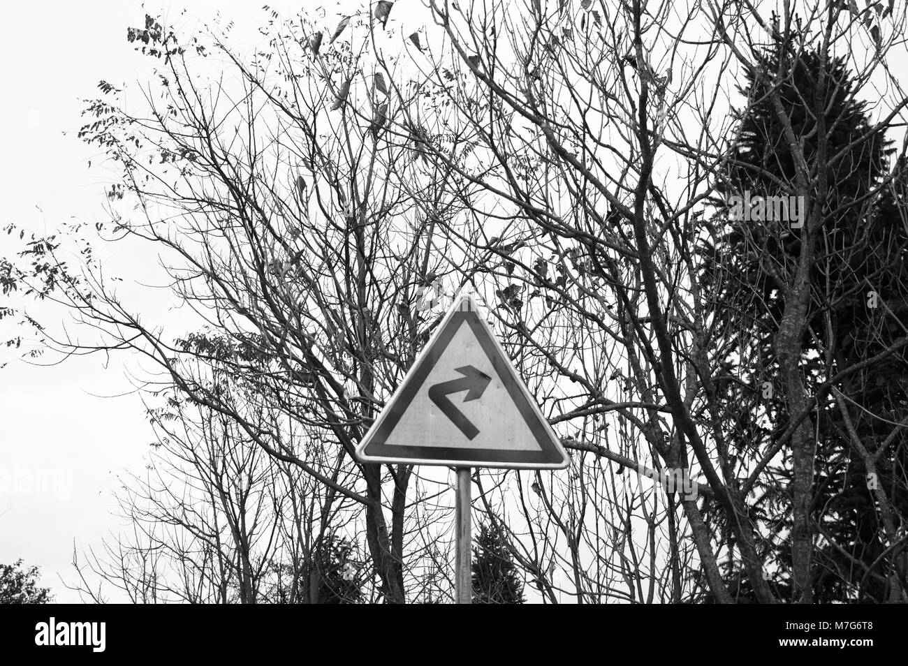 Noir et blanc - signal de la rue tourner à droite sur la route (Yunnan, Chine) Banque D'Images