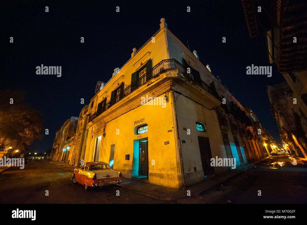 Une voiture américaine classique stationné à l'extérieur de la pharmacie à La Havane, Cuba, la nuit Banque D'Images