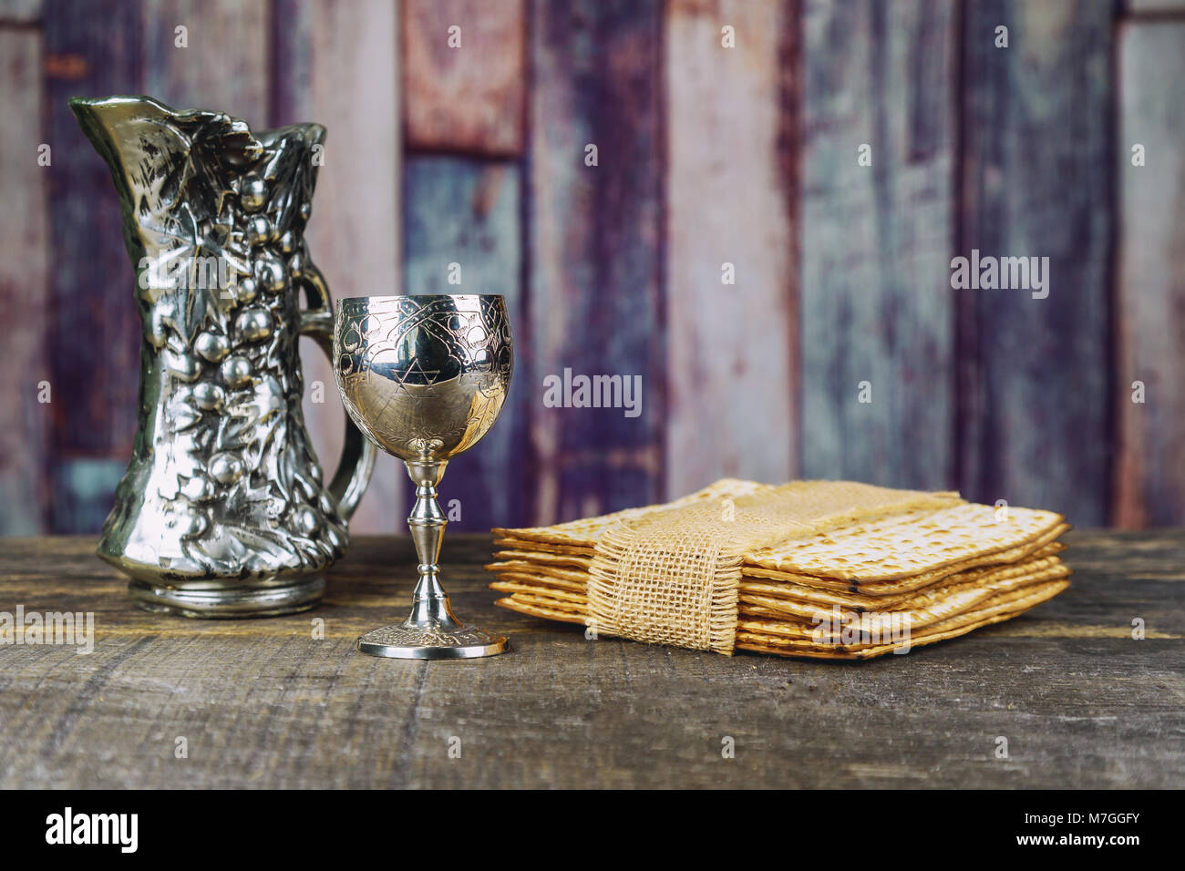 Vin casher rouge avec une plaque blanche de la matsa ou du pont et une Haggada de Pâque sur un fond de bois vintage Banque D'Images