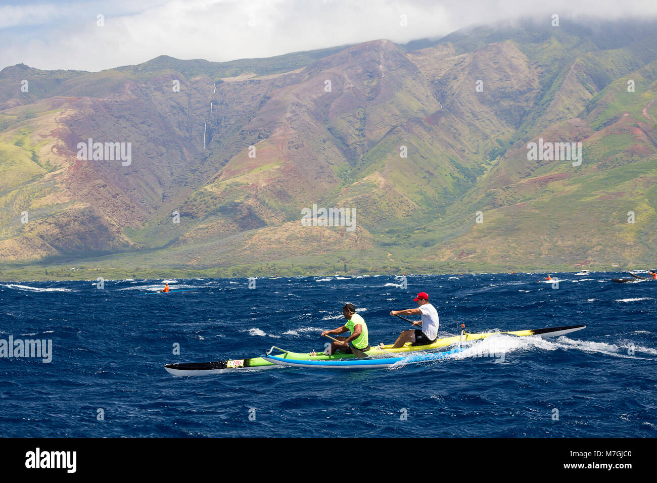 L'équipe de pagaie de deux hommes et de porter Shimer marque Keahi (MR) dans le Club de canoë-kayak de Maui's 2014 à Maui Molokai race de DT à Fleming Beach Banque D'Images