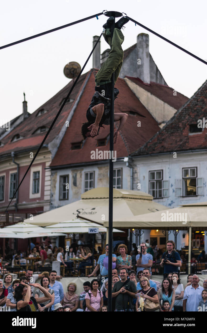 Un membre d'Kinemtatos Manoamano, Circo, l'Argentine d'effectuer un tour dans le petit square pendant le Festival International de Théâtre de Sibiu Banque D'Images