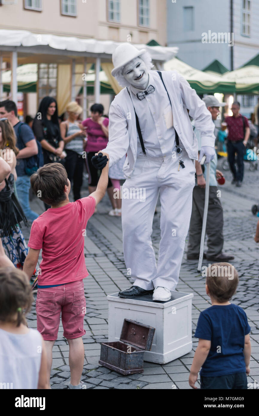 SIBIU, ROUMANIE - 17 juin 2016 : un mime est en serrant la main d'un garçon en grande place pendant le Festival International de Théâtre de Sibiu, Sibiu, Roamania. Banque D'Images