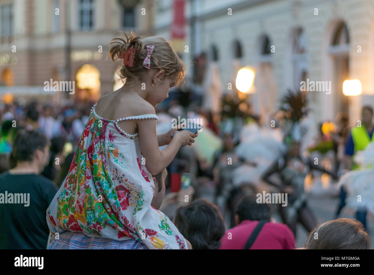SIBIU, ROUMANIE - 17 juin 2016 : une fille, c'est contrôler le téléphone alors que certains carnaval danses sont en cours, pendant le Festival International de Théâtre de Sibiu, à l'al. Banque D'Images