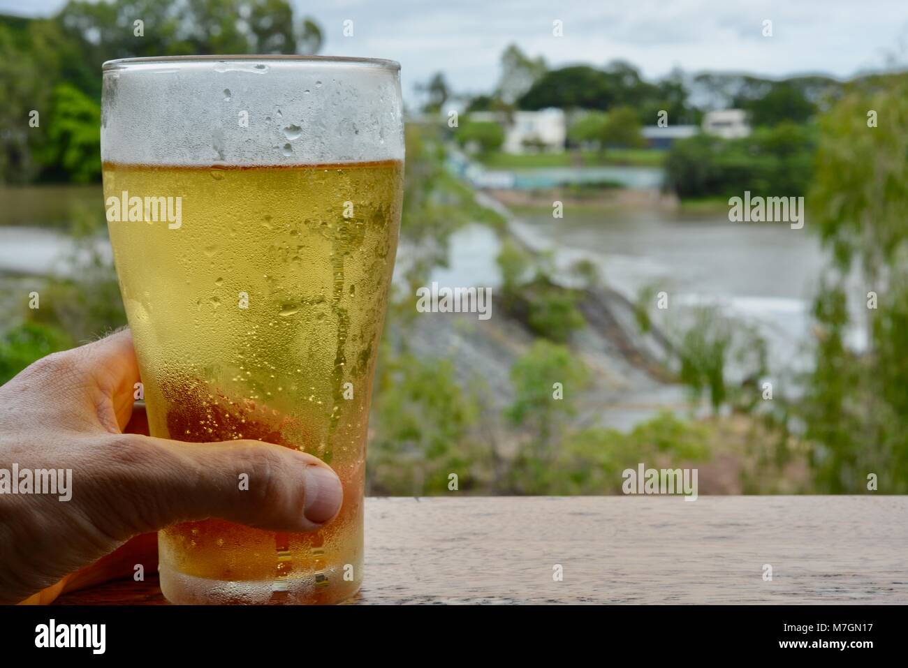 Boire une bière avec vue sur l'eau de déborder la Weir après de fortes pluies récentes, Riverview Taverne dans Douglas Queensland Australie Townsville Banque D'Images