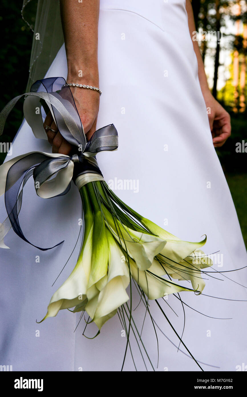 Sa bride holding bouquet de mariage lys blanc avec un ruban bleu à côté  d'elle Photo Stock - Alamy