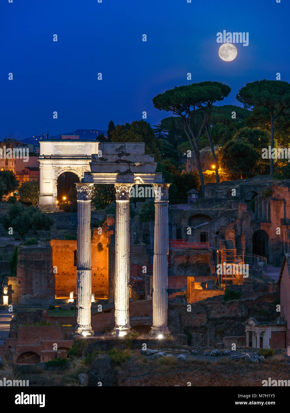 Pleine lune derrière Temple de Castor et Pollux et Arc de Titus, le Forum Romain, Rome, Italie Banque D'Images