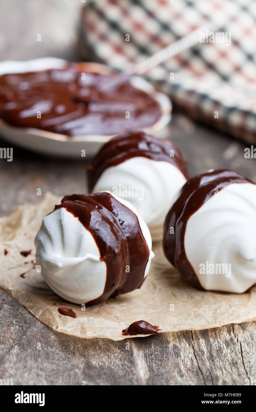 Des meringues blanches avec chocolat noir Banque D'Images