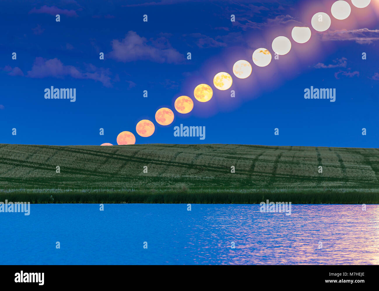 Laps de temps de la pleine lune sur l'étang une prairie en Alberta, Canada. Banque D'Images