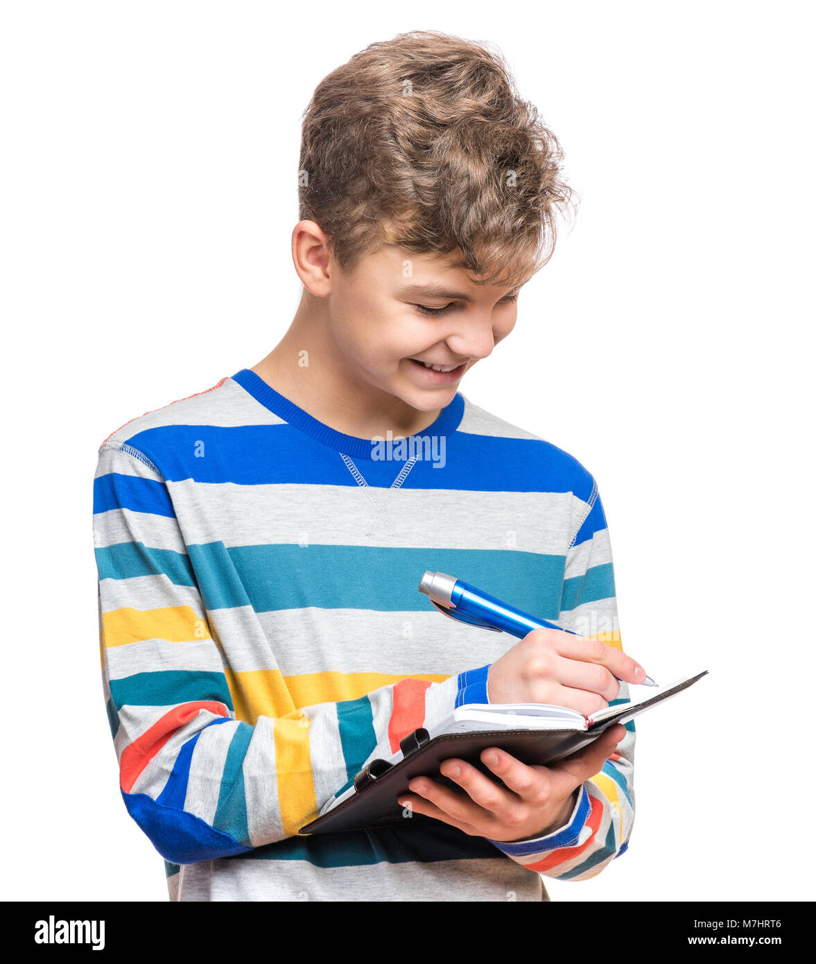 Teen boy avec stylo écrire quelque chose Banque D'Images