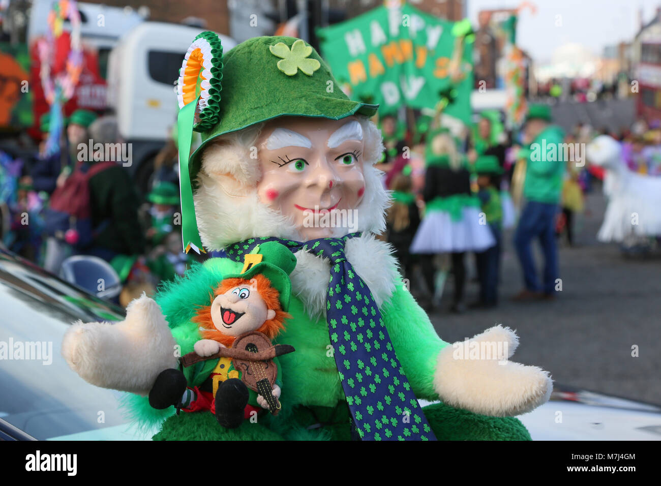 La communauté irlandaise de Birmingham célèbre la St Patrick's Day avec leur défilé annuel à travers les rues de la ville. Un modèle lutin se trouve sur un capot de voiture. Banque D'Images